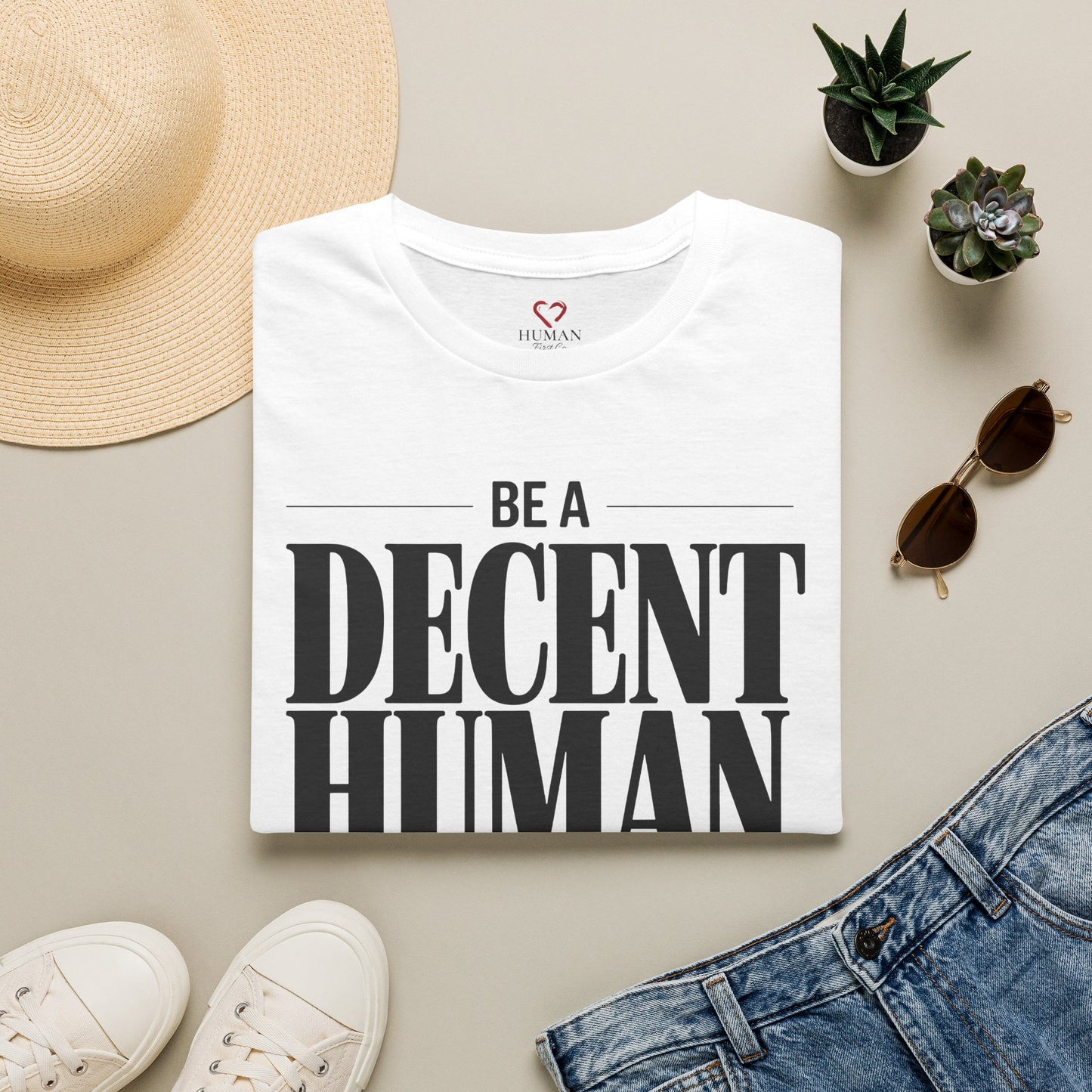 Folded humanitarian t-shirt featuring the Be A Decent Human design in a minimalist editorial presentation.