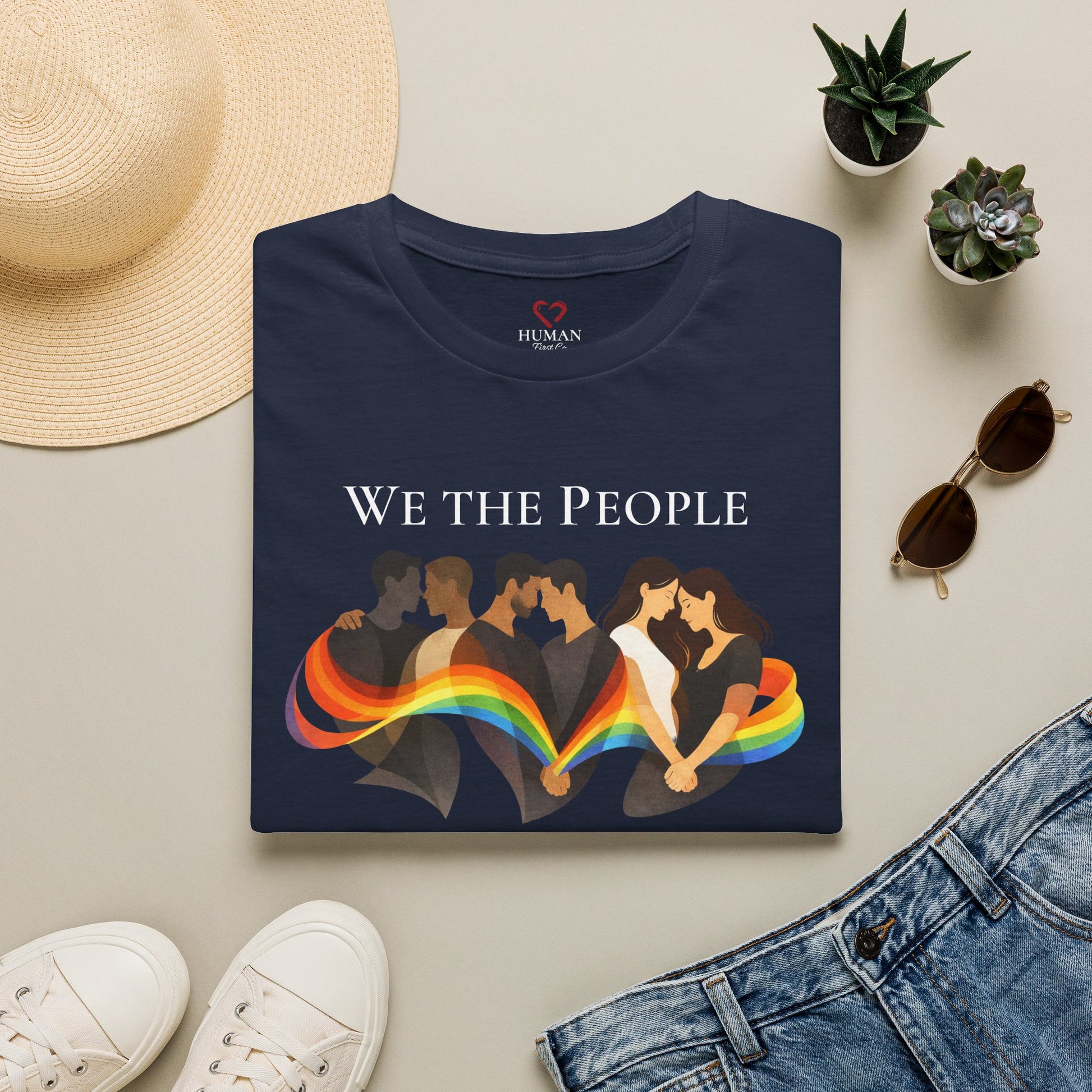 Folded humanitarian t-shirt featuring the We The People design in a minimalist editorial presentation.