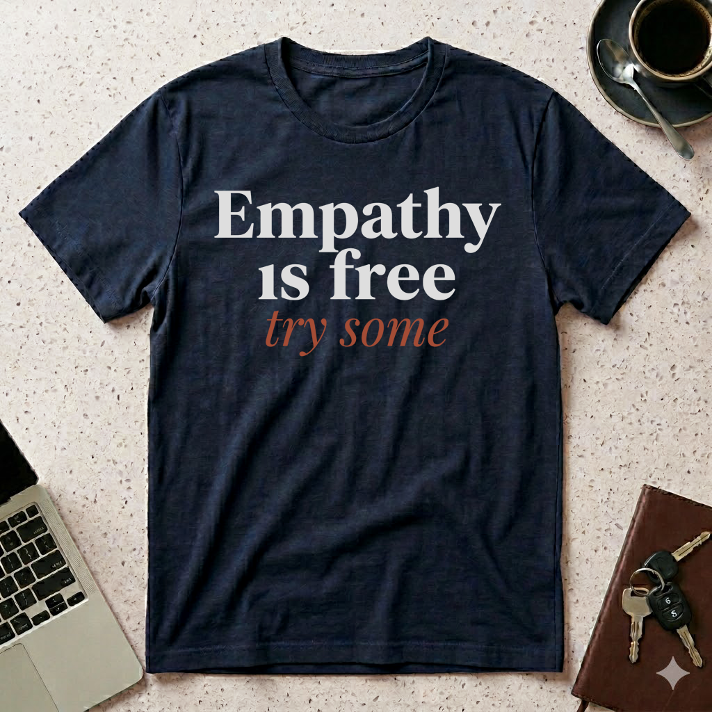 Navy humanitarian t-shirt featuring the message "Empathy Is Free" in minimalist editorial typography, promoting understanding, compassion, and human connection.