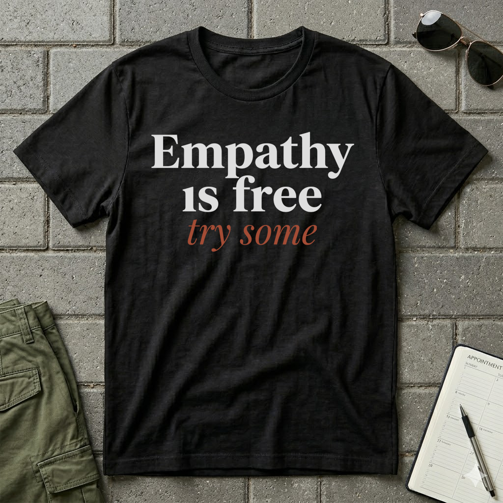 Black humanitarian t-shirt featuring the message "Empathy Is Free" in minimalist editorial typography, promoting understanding, compassion, and human connection.