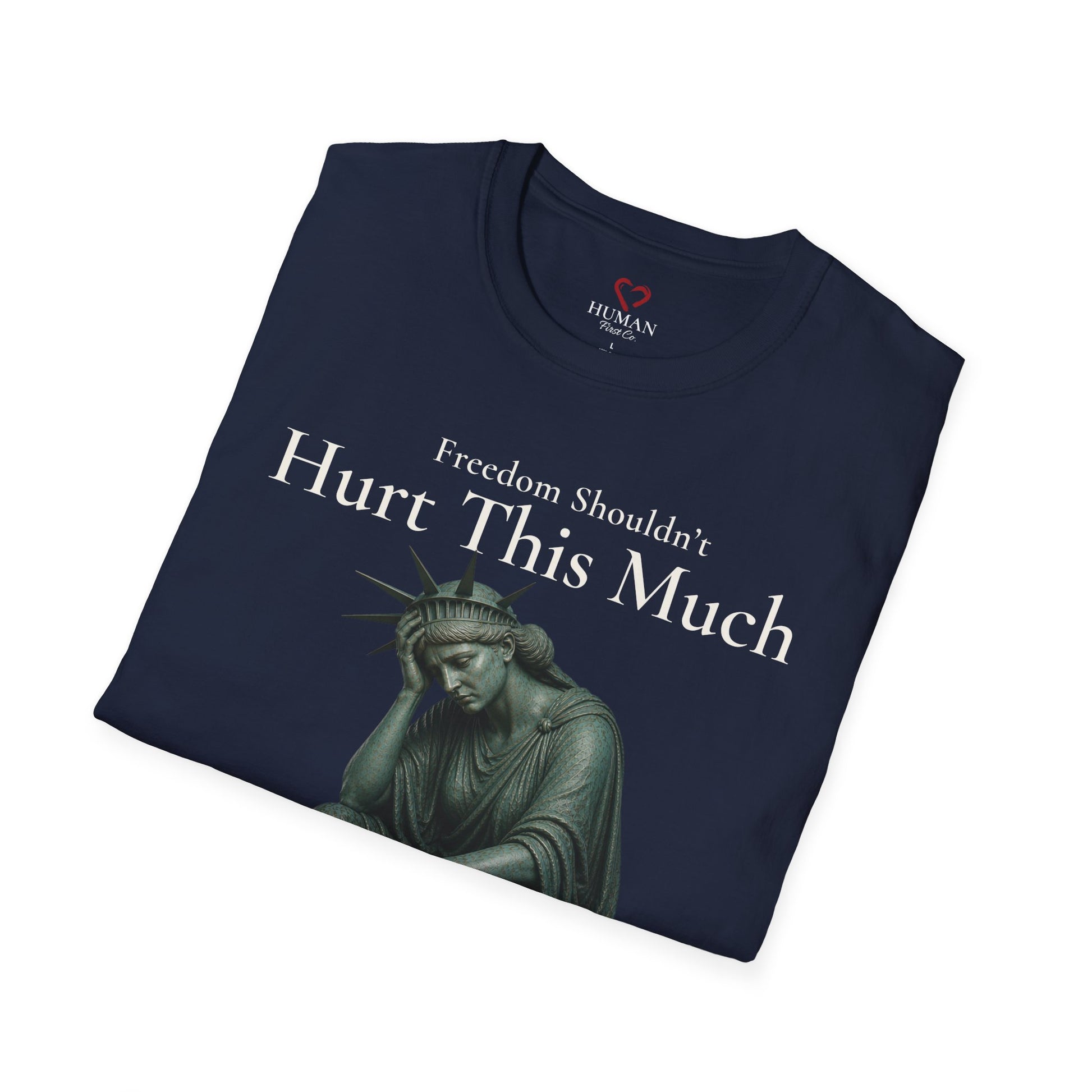 Folded humanitarian t-shirt featuring the Freedom Shouldn't Hurt This Much design in a symbolic editorial presentation.