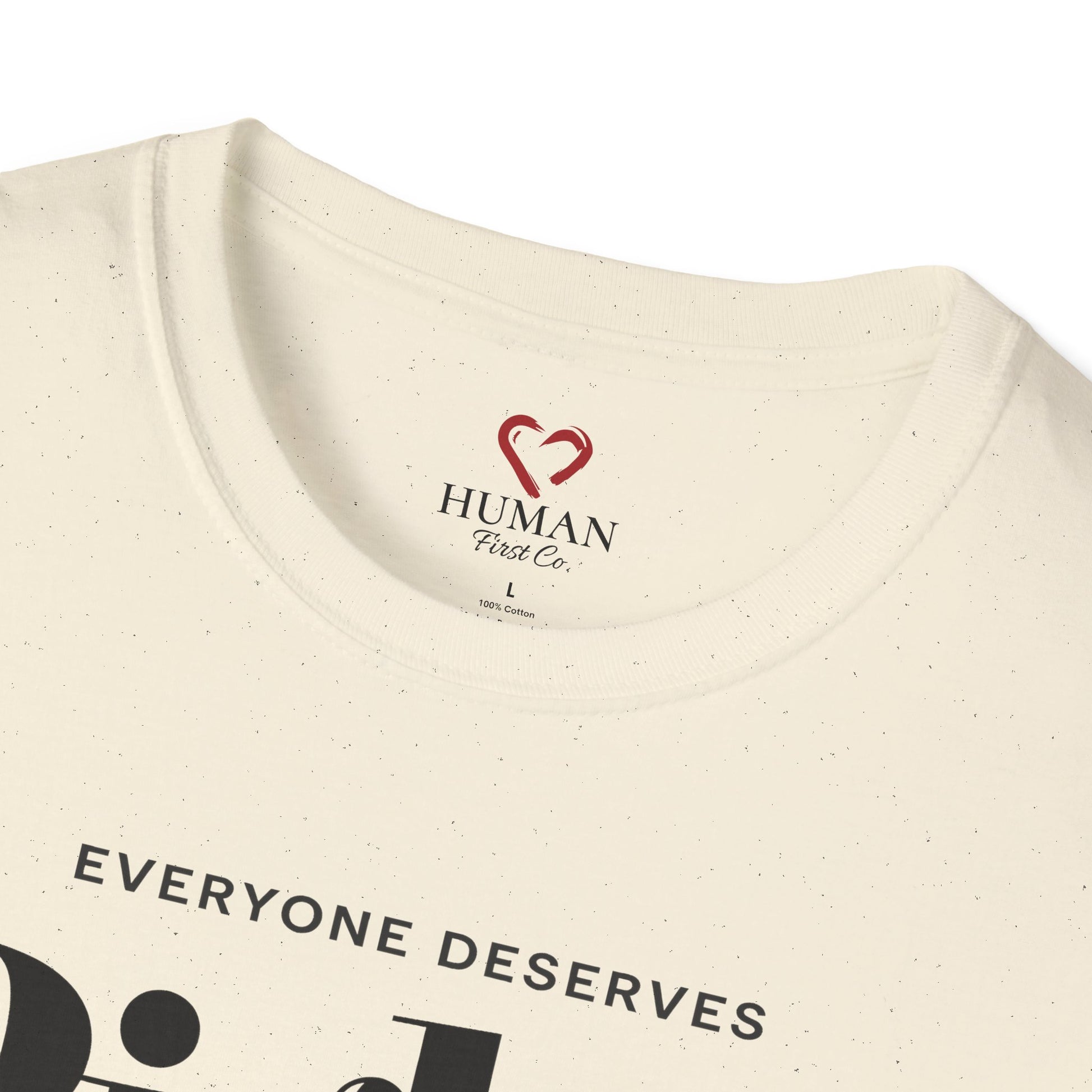 Close-up collar view of Human First Co. humanitarian t-shirt showing branded neck label and garment details.